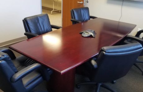 medium sized conference table and high back office chairs