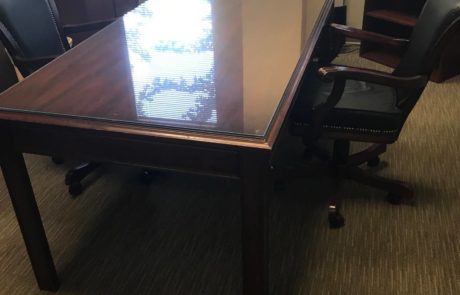 large conference table with black high back office chairs